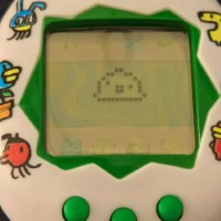 a photograph of the tamagotchi, the egg replaced with a blob-like creature.